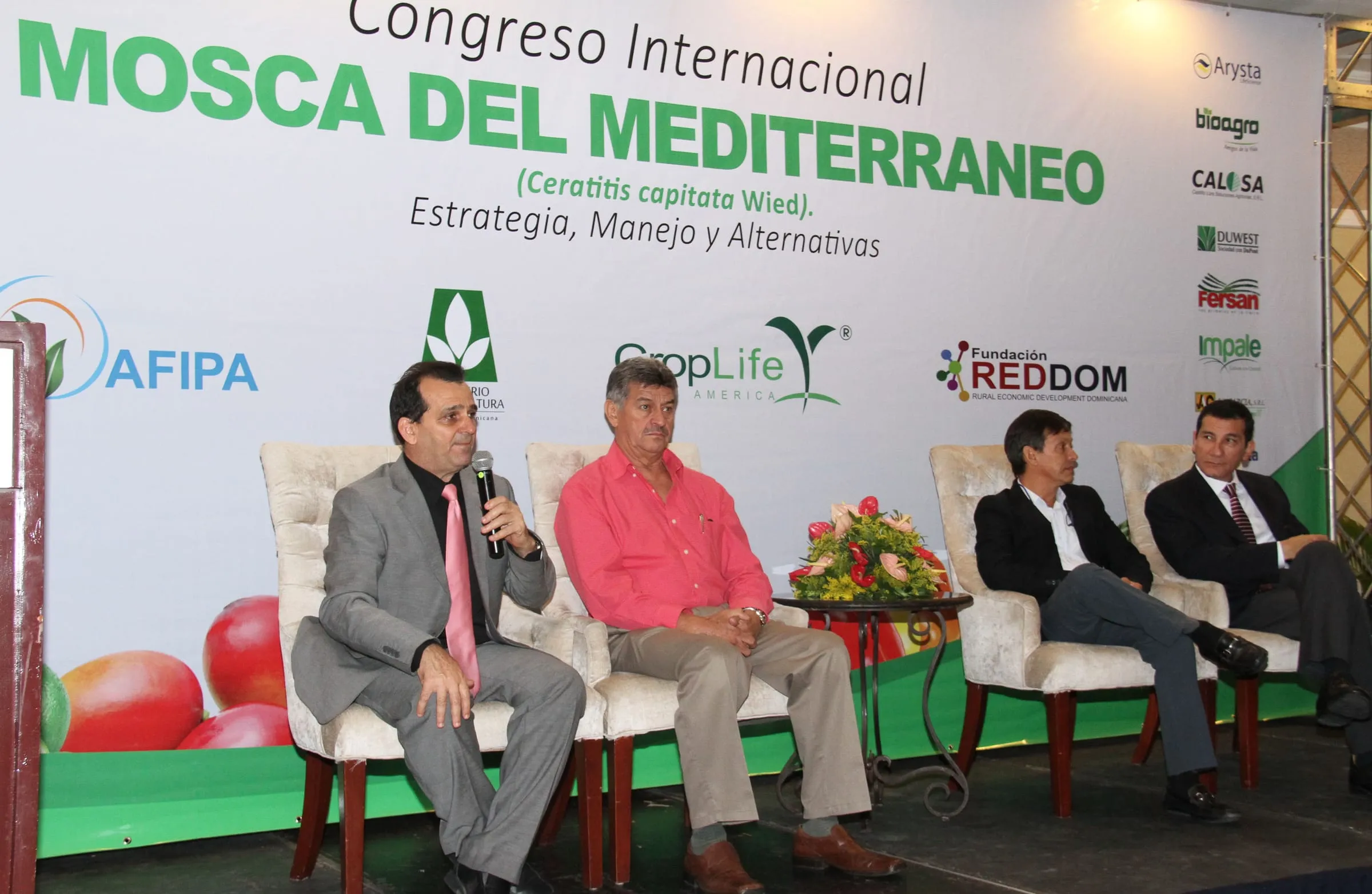 Cuatro panelistas conversan sentados en el escenario del congreso, frente al banner con los logos de AFIPA, CropLife Latin America y las empresas socias