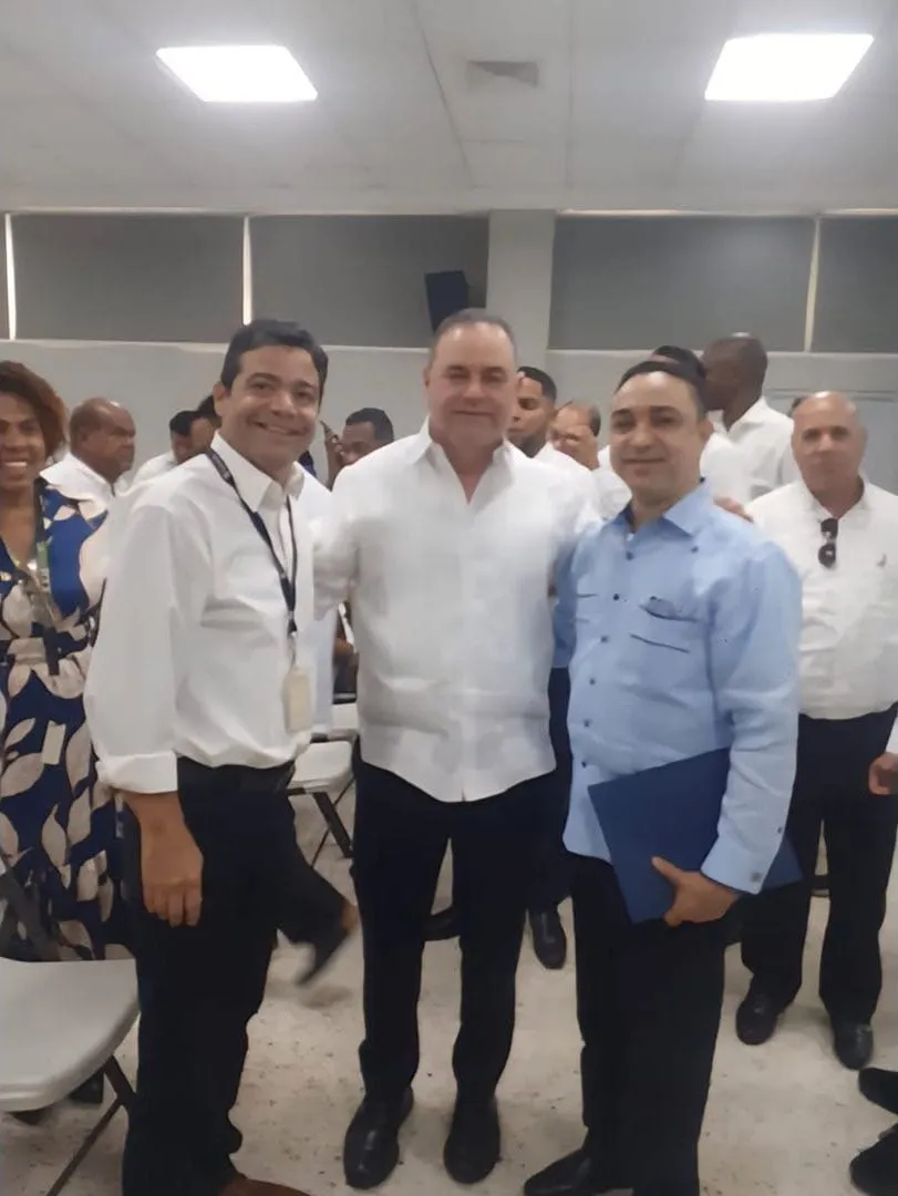 El ministro de Agricultura posa con participantes del acto, con el público detrás