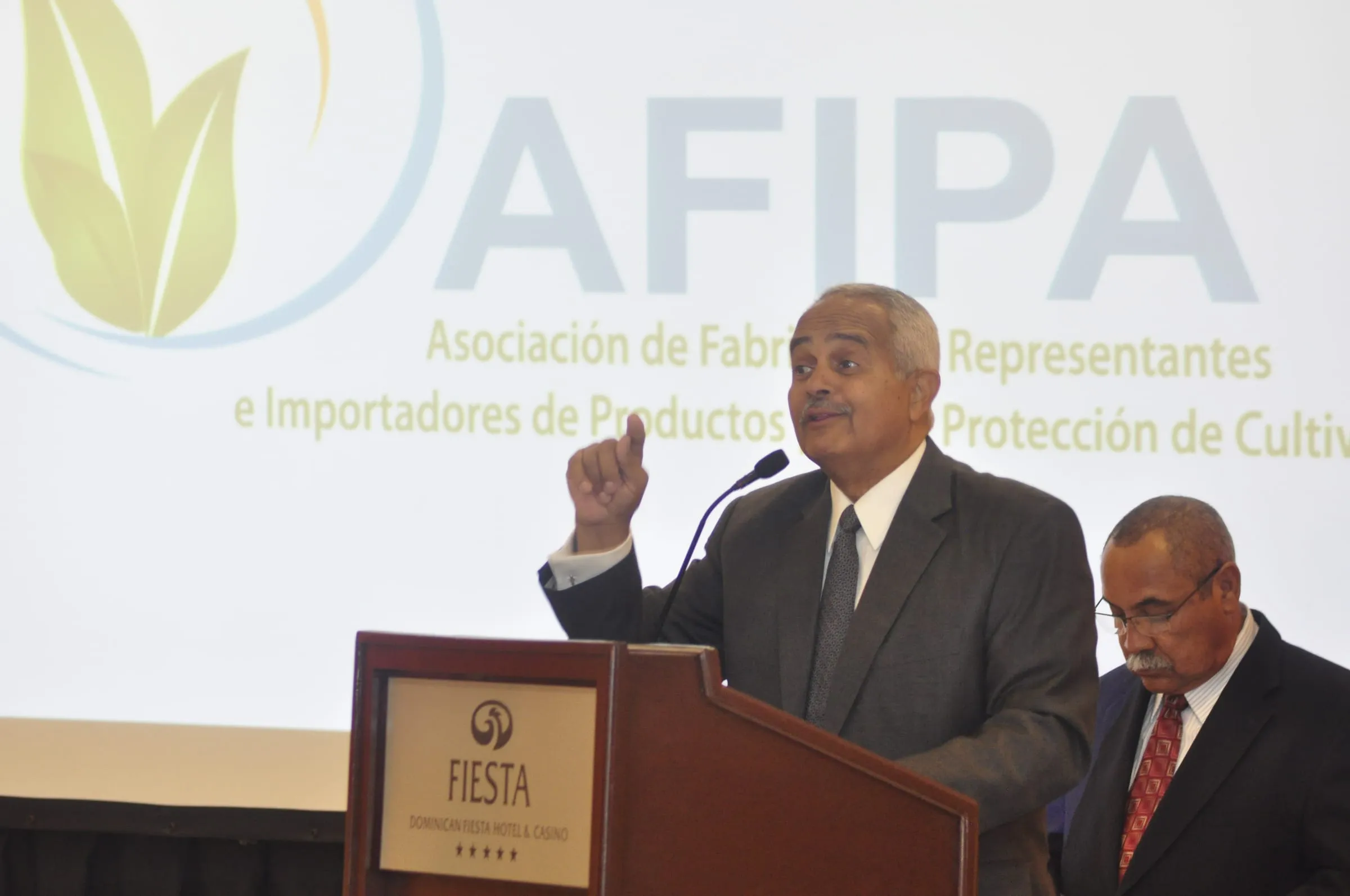 Un directivo pronuncia el discurso de apertura desde el pódium, con el logo y el nombre completo de AFIPA proyectados a toda pantalla detrás